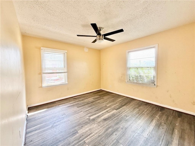 empty room with baseboards, a textured ceiling, wood finished floors, and a ceiling fan