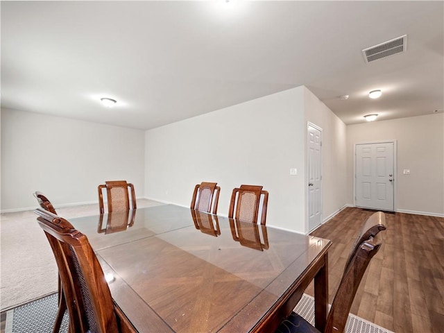 dining space with baseboards, visible vents, and wood finished floors