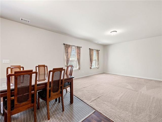 dining area with carpet, visible vents, and baseboards