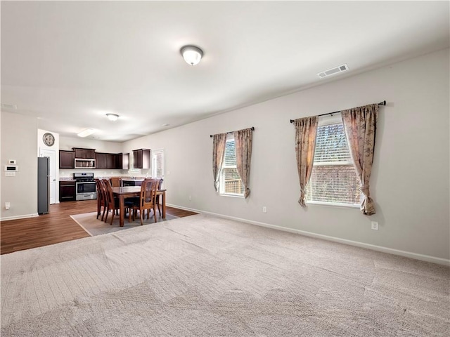 carpeted dining room featuring visible vents and baseboards