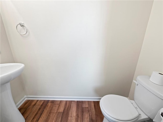 bathroom featuring wood finished floors, toilet, and baseboards