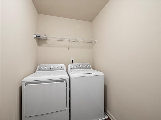 laundry area featuring laundry area, baseboards, and separate washer and dryer