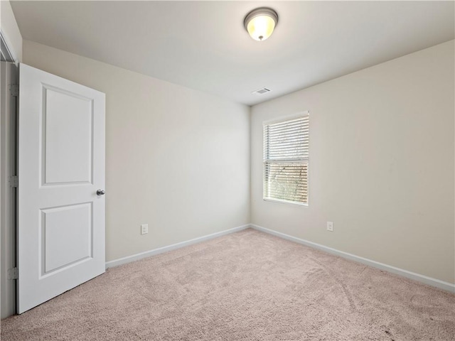 spare room with carpet, visible vents, and baseboards