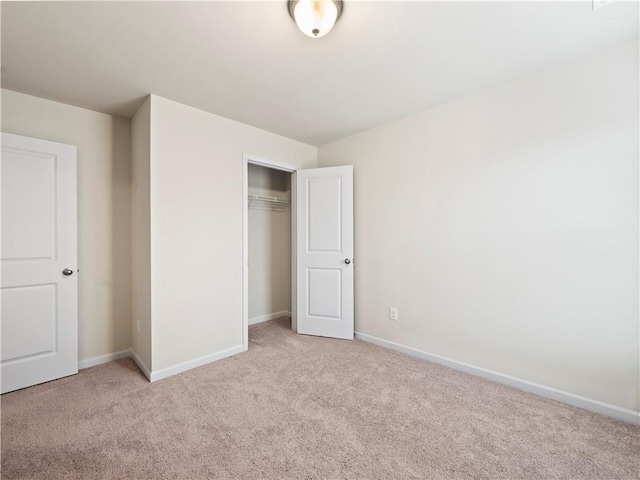 unfurnished bedroom with carpet, a closet, and baseboards