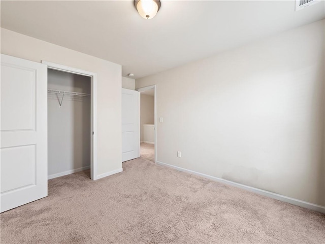 unfurnished bedroom with carpet floors, visible vents, baseboards, and a closet