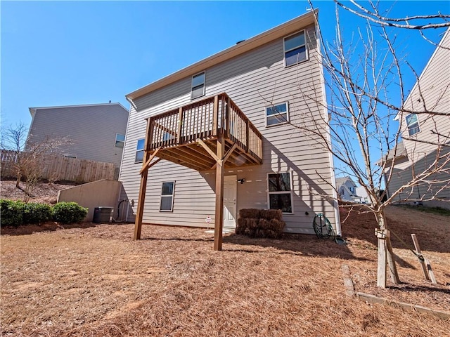 back of property featuring fence, a wooden deck, and central AC unit