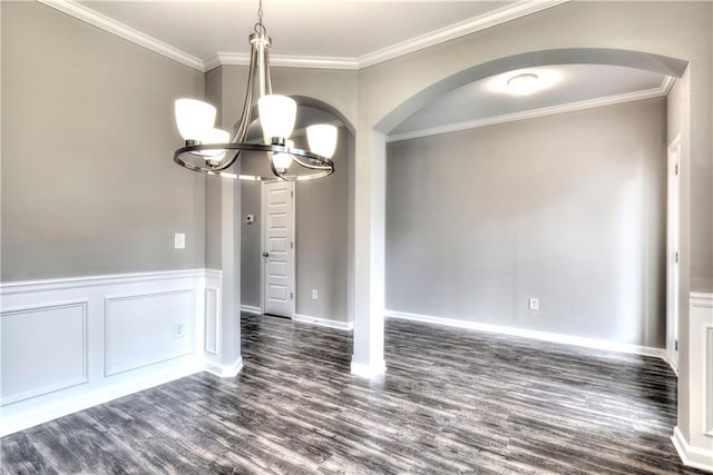 empty room with dark hardwood / wood-style flooring, crown molding, and a chandelier