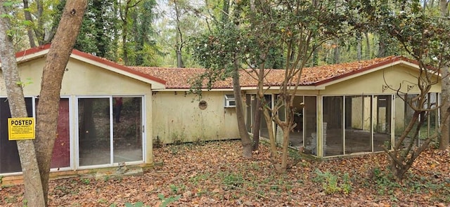 rear view of property featuring a sunroom