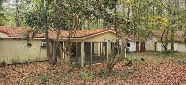 rear view of property featuring a sunroom