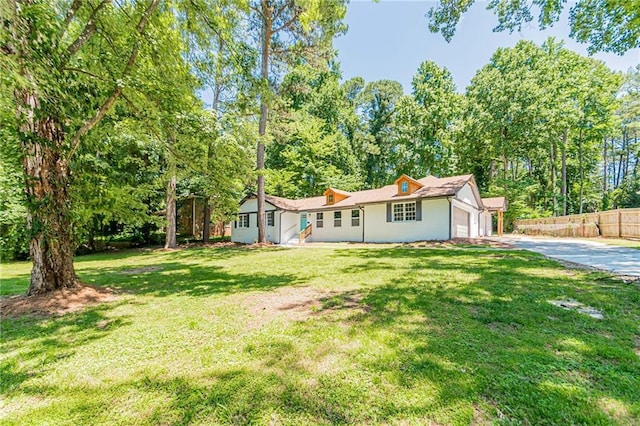 single story home with an attached garage, fence, driveway, and a front lawn