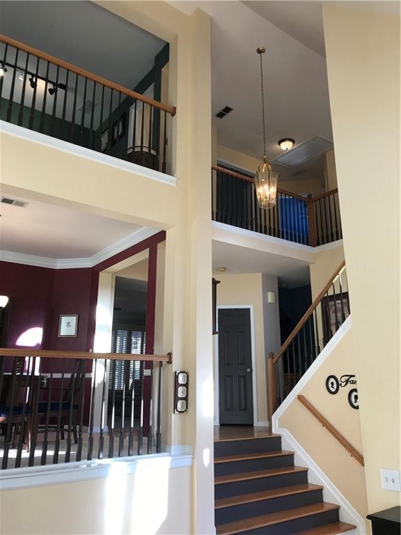 stairs featuring an inviting chandelier and a high ceiling