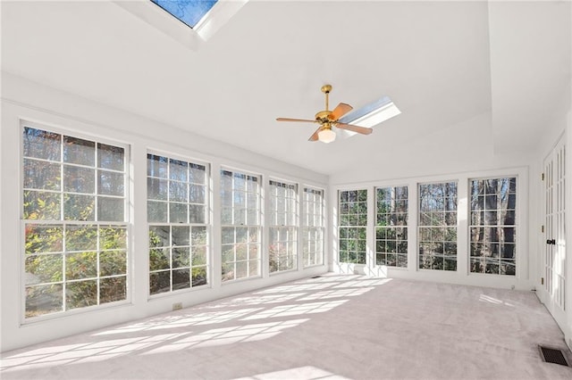 unfurnished sunroom with ceiling fan and vaulted ceiling with skylight