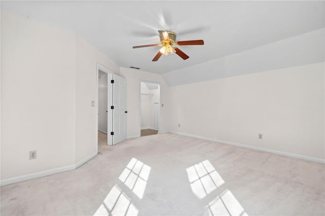 empty room featuring ceiling fan, light colored carpet, and lofted ceiling