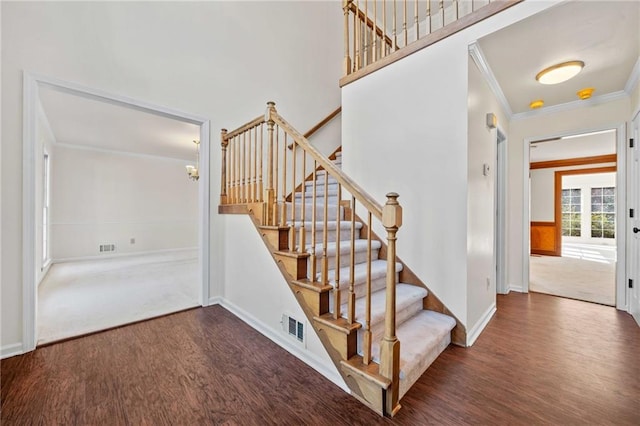 stairs featuring hardwood / wood-style floors and crown molding