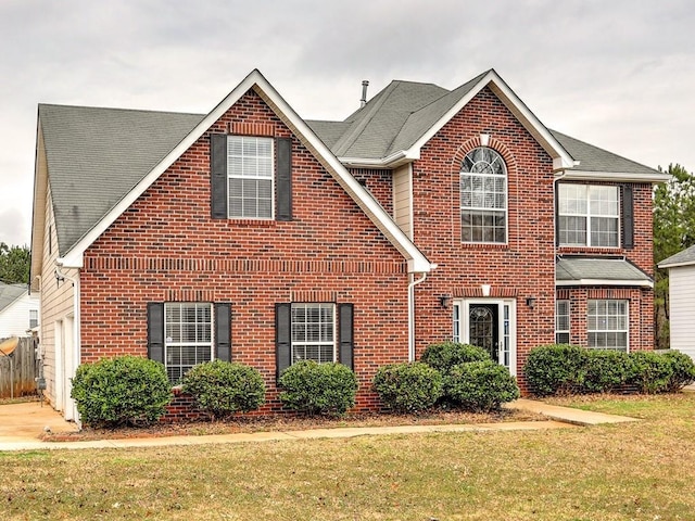 traditional home with brick siding and a front yard