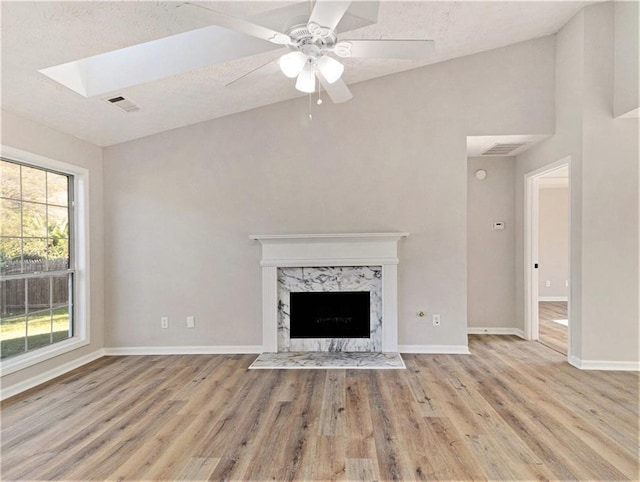 unfurnished living room with wood finished floors, visible vents, and baseboards