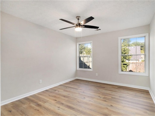 unfurnished room with light wood-type flooring, plenty of natural light, baseboards, and ceiling fan