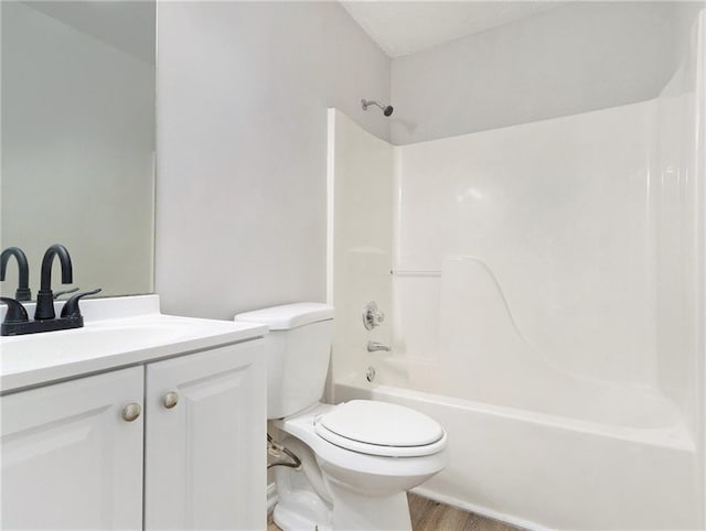 full bath with toilet, shower / tub combination, wood finished floors, and vanity