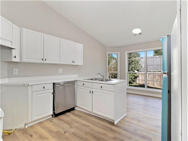 kitchen with white cabinets, lofted ceiling, a peninsula, stainless steel dishwasher, and a sink