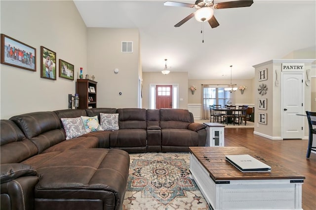 living area with a ceiling fan, baseboards, visible vents, and wood finished floors