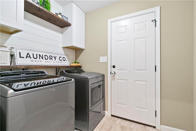 laundry area featuring cabinet space, baseboards, and washer and dryer