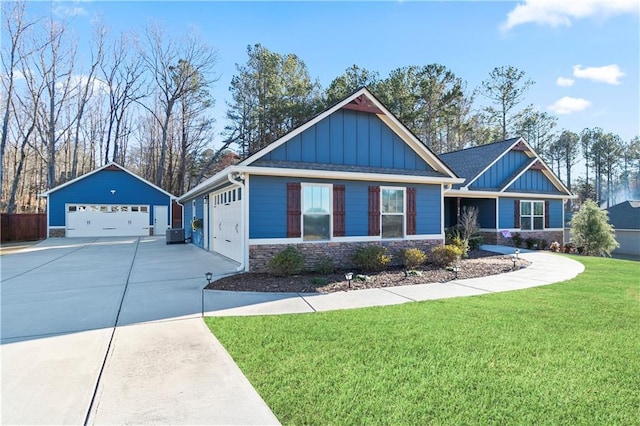 craftsman inspired home with a garage, stone siding, an outbuilding, board and batten siding, and a front yard