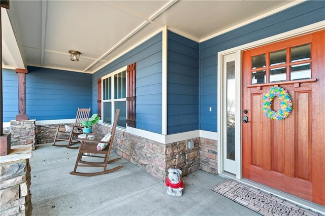 property entrance featuring a porch and stone siding