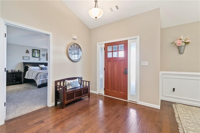 foyer with vaulted ceiling, hardwood / wood-style floors, visible vents, and baseboards