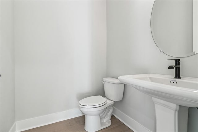 bathroom with hardwood / wood-style floors, toilet, and sink