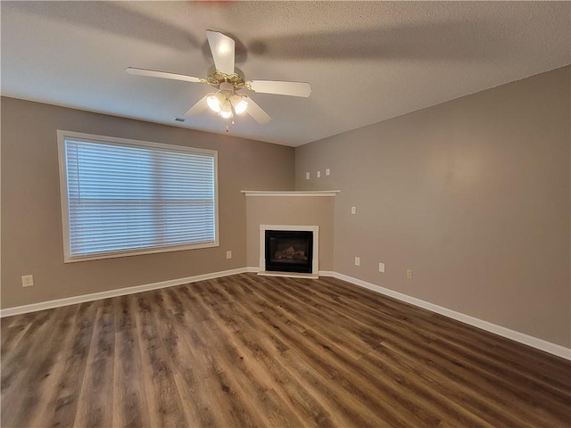 285 Fieldview Ln, Covington, GA 30016 - unfurnished living room featuring wood finished floors, a fireplace with flush hearth, ceiling fan, and a textured ceiling