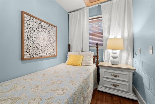 bedroom featuring dark hardwood / wood-style floors and a skylight