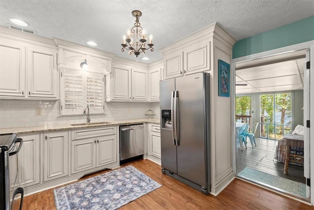 kitchen featuring appliances with stainless steel finishes, white cabinetry, sink, and light hardwood / wood-style floors