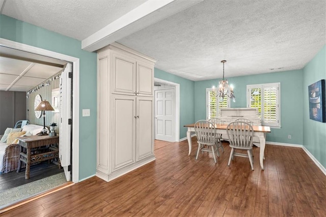 dining space featuring a textured ceiling, a notable chandelier, and wood-type flooring