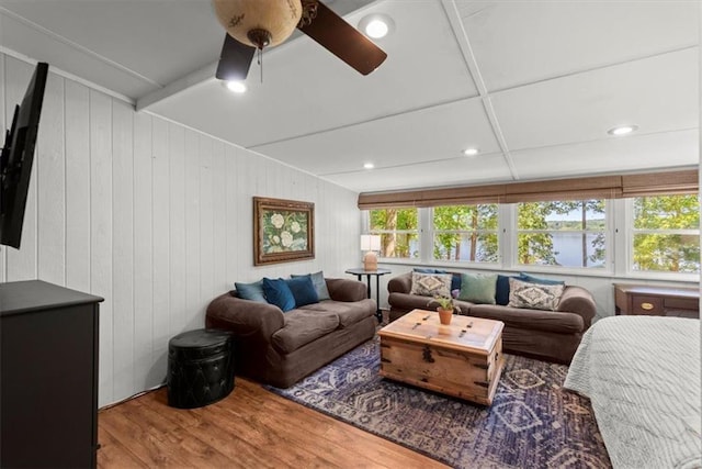 living room featuring wood walls, hardwood / wood-style floors, and ceiling fan