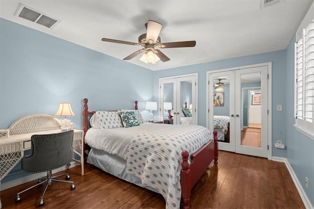 bedroom featuring french doors, multiple closets, dark wood-type flooring, and ceiling fan