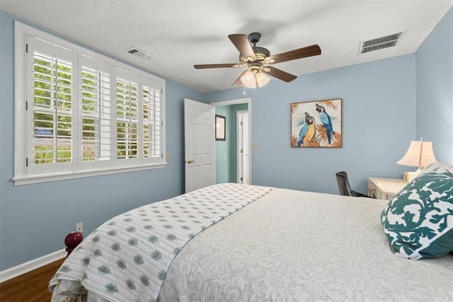 bedroom with dark hardwood / wood-style flooring and ceiling fan