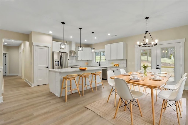 dining area featuring a notable chandelier, light wood-type flooring, and sink