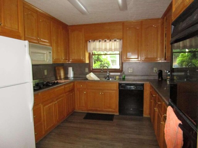 kitchen with dark hardwood / wood-style floors, black appliances, tasteful backsplash, and sink