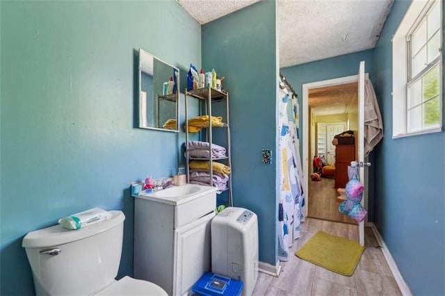 151 Grandma Branch Rd, Grantville, GA 30220 - bathroom with a textured ceiling, vanity, curtained shower, baseboards, and toilet
