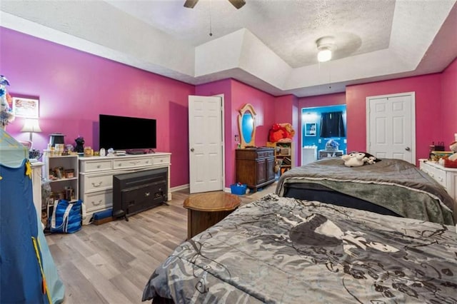 151 Grandma Branch Rd, Grantville, GA 30220 - bedroom featuring a tray ceiling, wood finished floors, baseboards, a textured ceiling, and ceiling fan