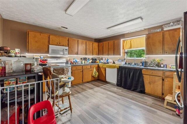151 Grandma Branch Rd, Grantville, GA 30220 - kitchen featuring brown cabinets, a textured ceiling, and white appliances