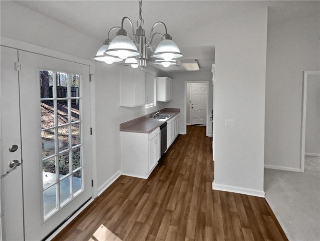 kitchen featuring dark hardwood / wood-style flooring, dishwasher, white cabinets, a chandelier, and hanging light fixtures