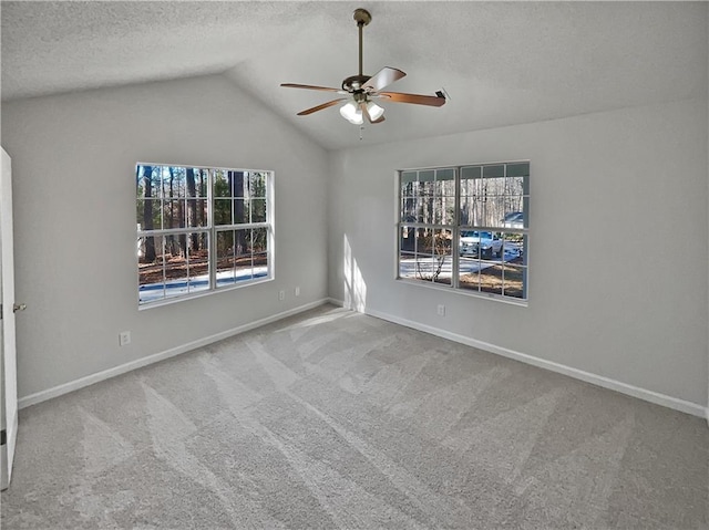 empty room featuring carpet flooring, ceiling fan, lofted ceiling, and a textured ceiling