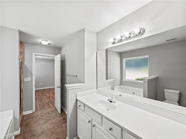 498 Walnut Woods Dr, Braselton, GA 30517 - bathroom with a bath, visible vents, baseboards, vanity, and toilet