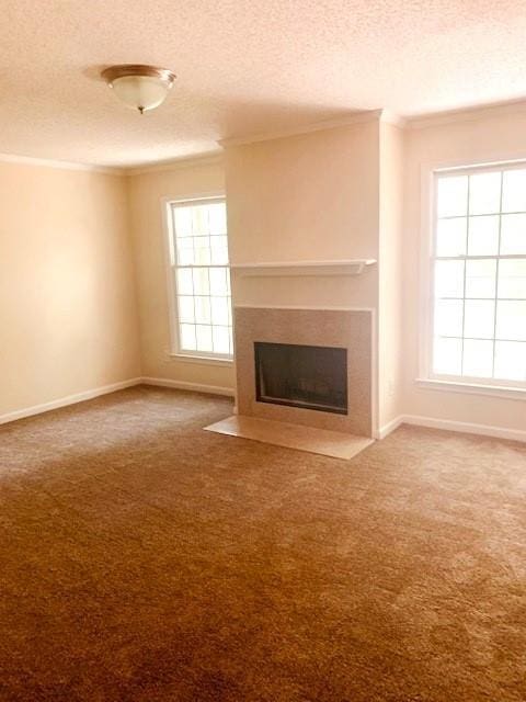 unfurnished living room featuring carpet floors, a textured ceiling, and crown molding