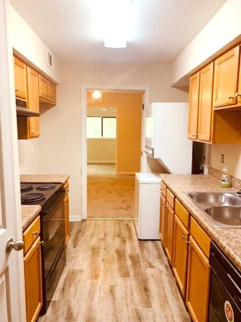 kitchen with light hardwood / wood-style floors, sink, a textured ceiling, and black appliances