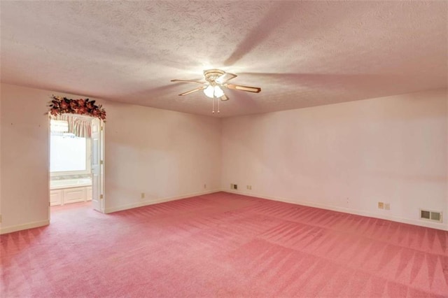 carpeted spare room featuring ceiling fan and a textured ceiling