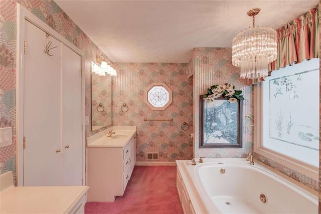 bathroom featuring vanity, a notable chandelier, and a bathtub