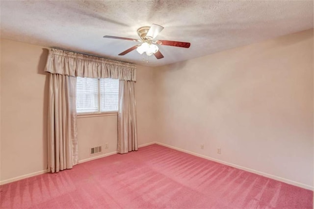 carpeted empty room with ceiling fan and a textured ceiling