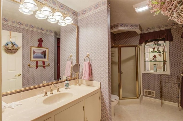 bathroom with tile patterned flooring, vanity, a shower with door, and toilet